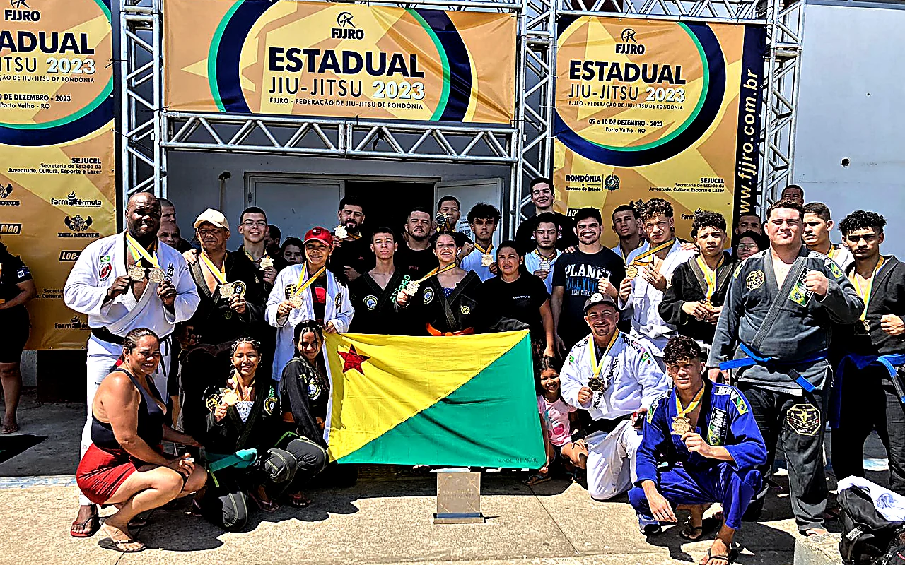 Delegação de atletas do projeto Combate pelo Bem e da RF Team com a bandeira do Acre em campeonato estadual